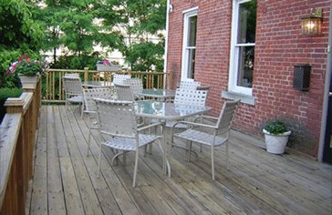 The deck at Generations, set with tables and chairs beside the brick house